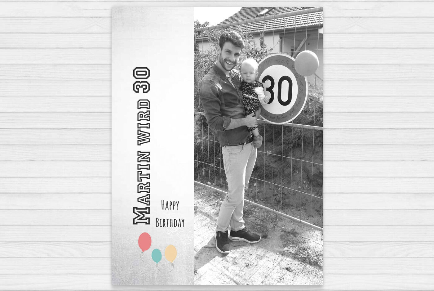 Ein Mann feiert seinen 30. Geburtstag mit einem Kind und einer 30er Geburtstagstafel.