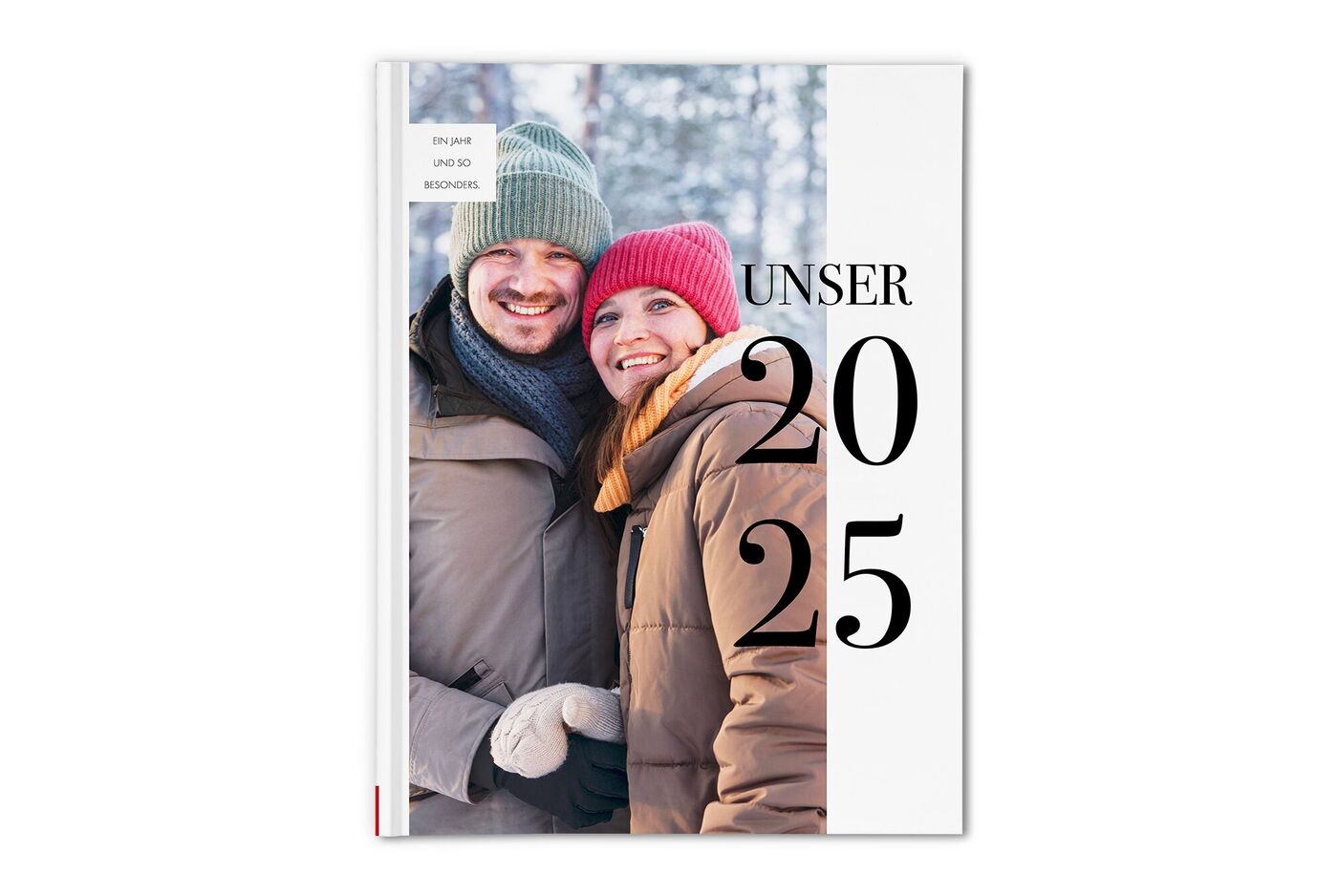 CEWE FOTOBUCH mit Paar in Winterkleidung vor verschneiten Bäumen und der Aufschrift Unser Jahr