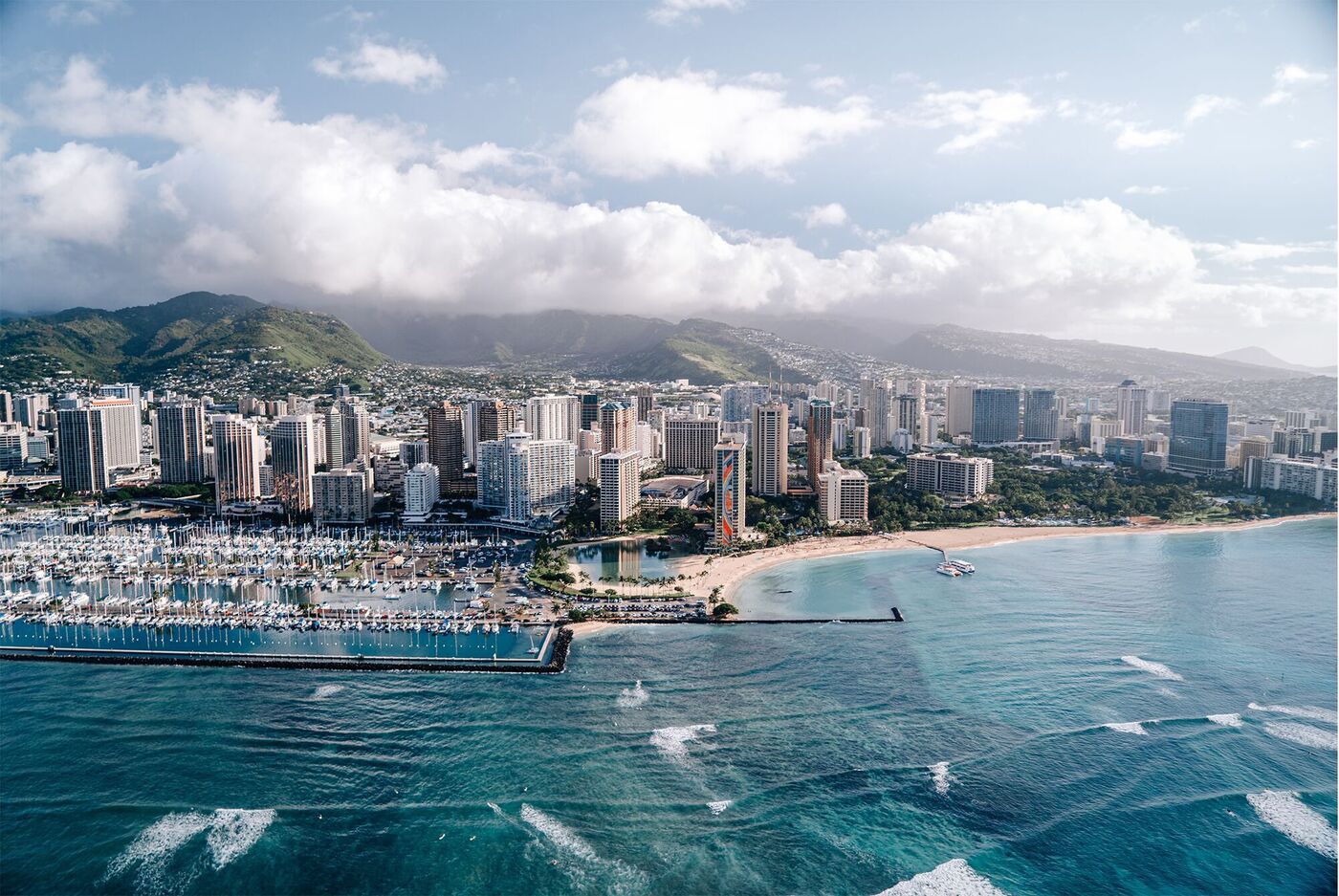 Luftaufnahme von Honolulu mit Strand und Wolken über der Stadt