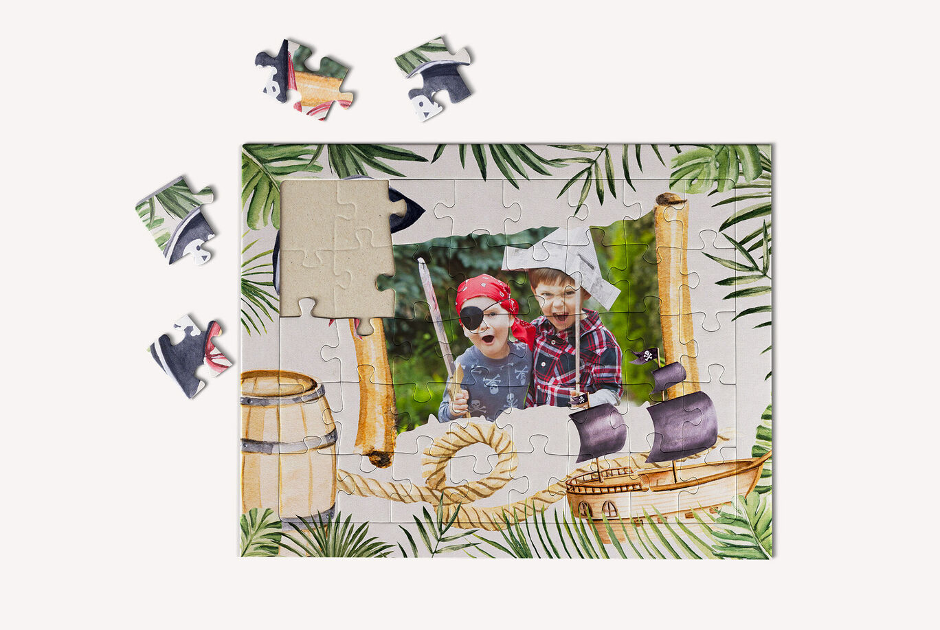 Ein liebevolles Puzzle mit einem maritimen Motiv, umgeben von einzelnen Puzzlestücken. Das Bild zeigt zwei Kinder in Piratenkostümen.