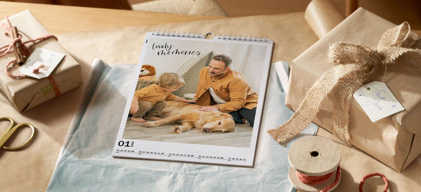 Ein wundervoller Fotokalender mit einem Bild von einem Mann, einem kleinen Kind und einem Hund, die gemeinsam auf einem Teppich im Wohnzimmer sitzen.