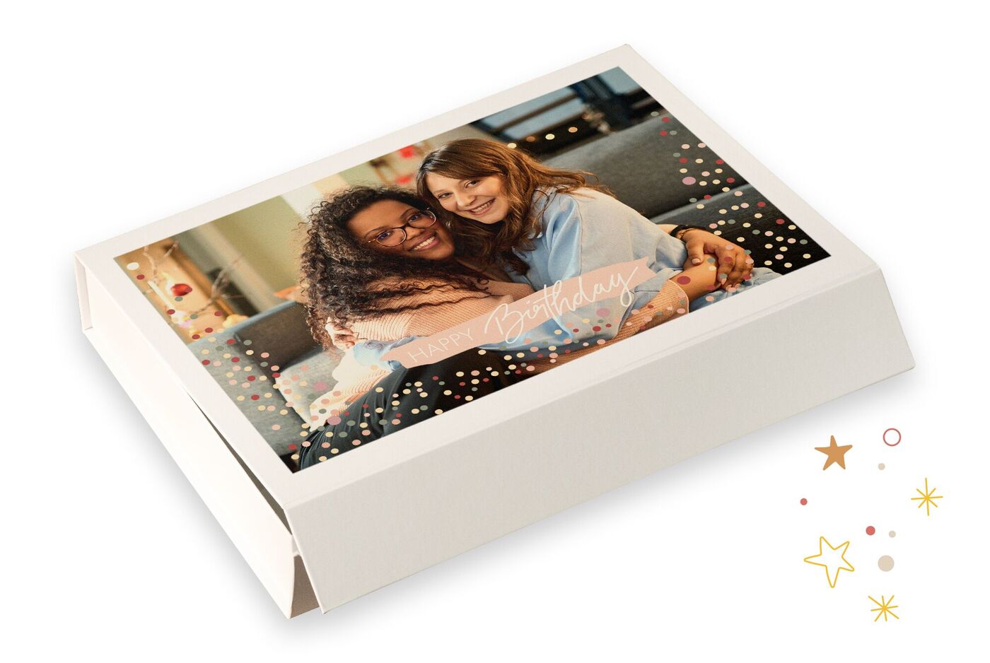 Zwei lächelnde Frauen umarmen sich glücklich auf einem Geschenk. Die Verpackung ist liebevoll dekoriert.