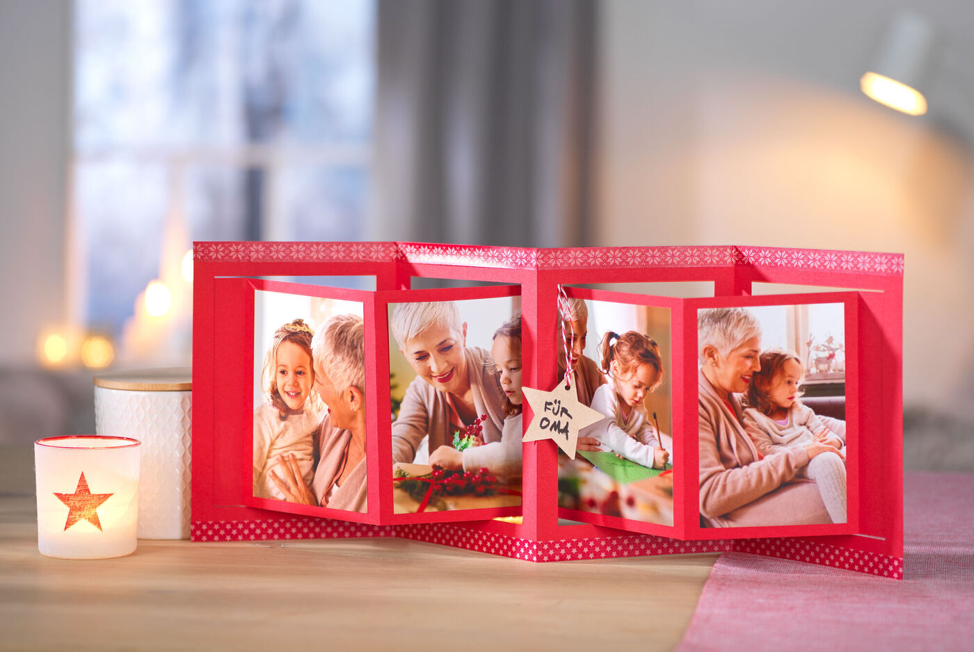 Rotes Fotobuch mit Familienbildern auf einem Tisch