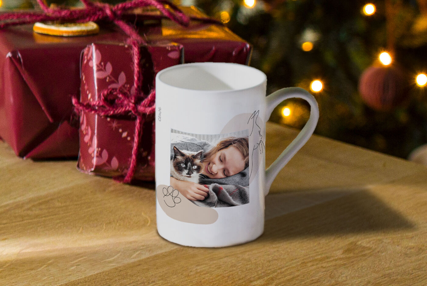 Tasse mit einem Foto von einer lächelnden Frau und ihrer Katze, umgeben von Weihnachtsdekorationen.