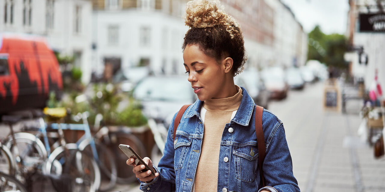 Junge Frau mit Smartphone in der Stadt